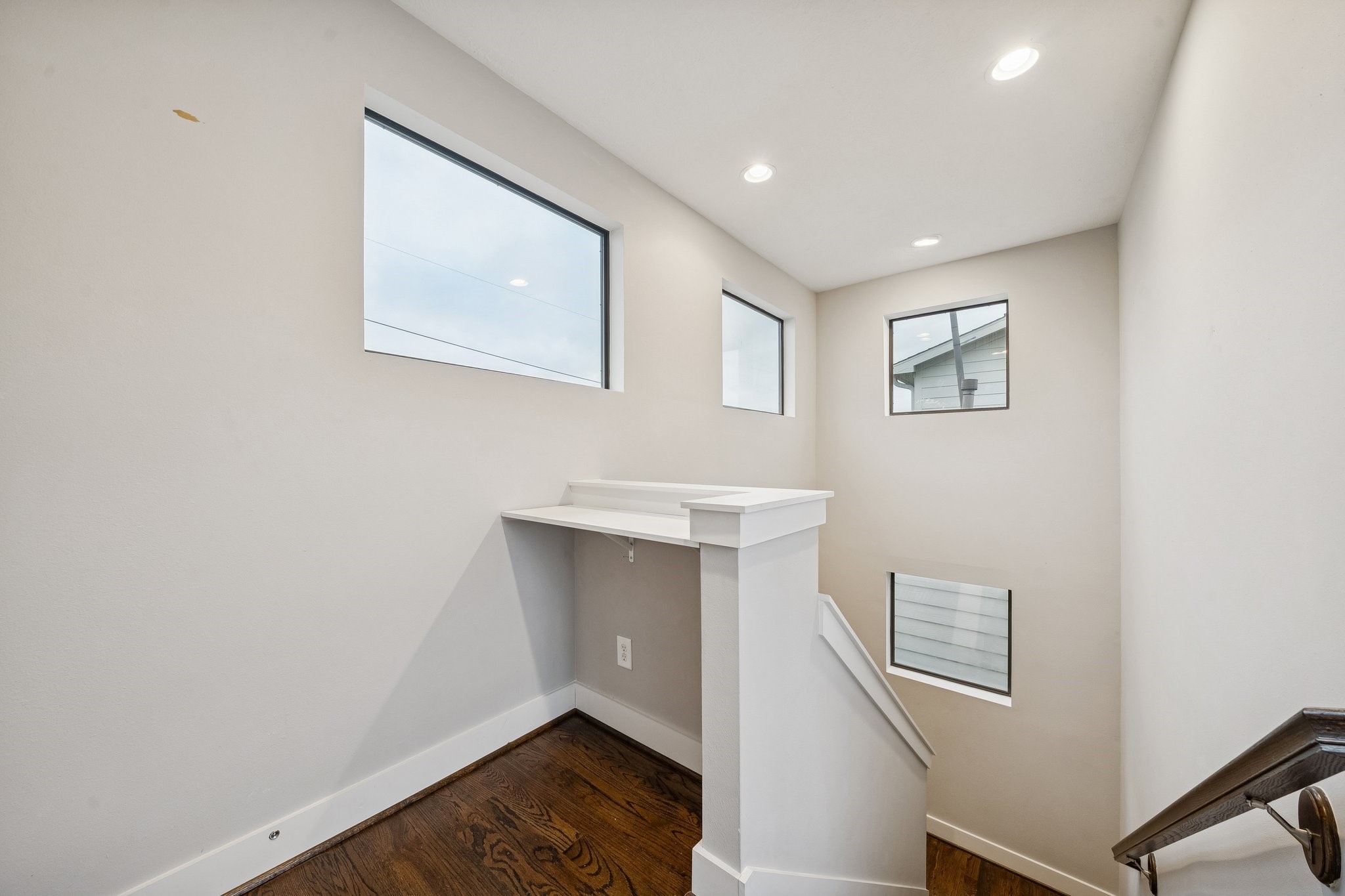 2105 Mason Street Houston, TX 77006 - Photo 16 of 43 The landing includes a built-in desk nook—perfect for homework, a quick email spot, or a dedicated drop zone for daily essentials. Multiple windows along the stairwell bring in daylight. It’s a smart use of space that adds function without taking away from the bedrooms.
