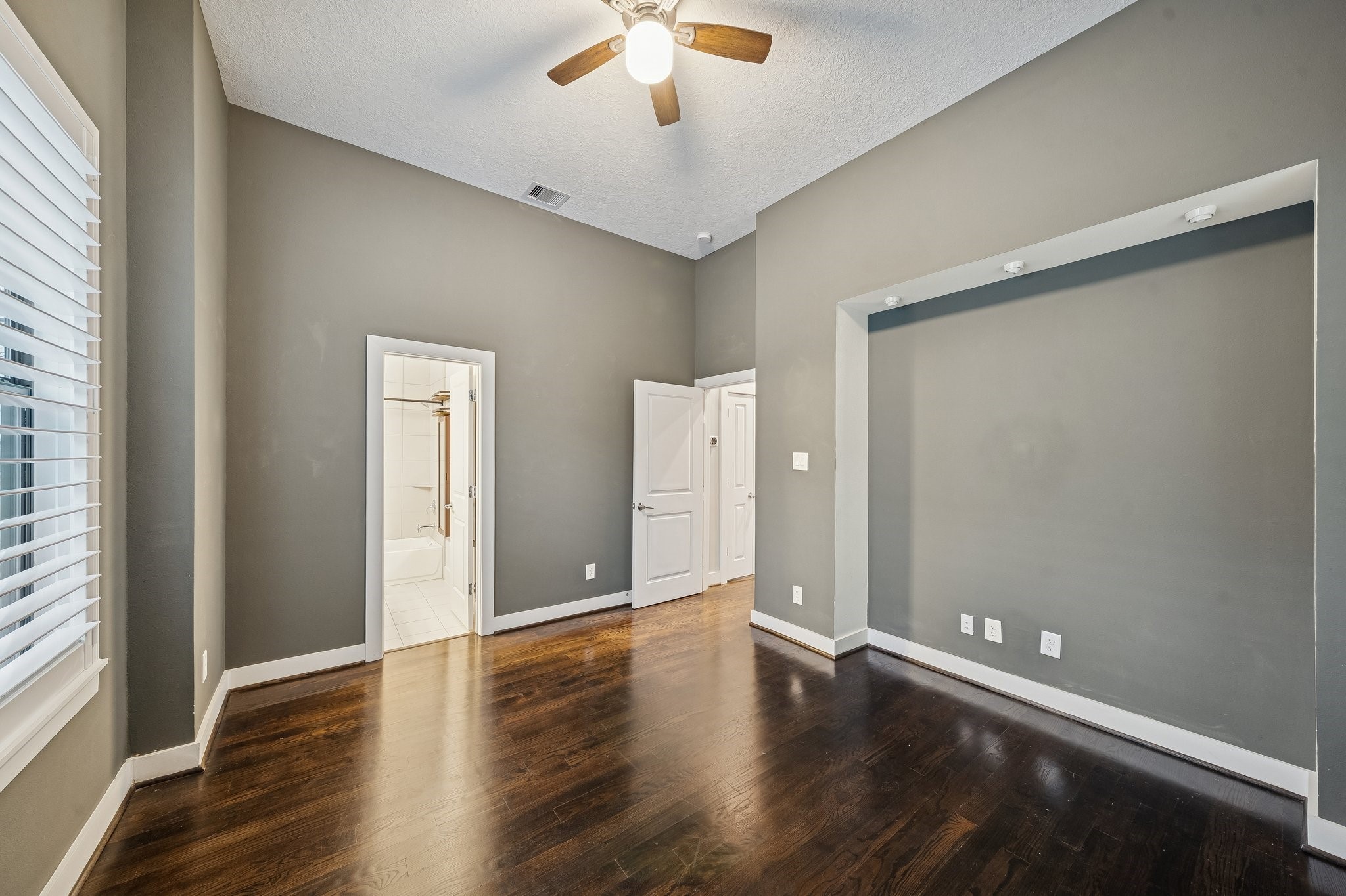2105 Mason Street Houston, TX 77006 - Photo 21 of 43 Secondary bedroom offers hardwood flooring, a ceiling fan, and great natural light from multiple windows with blinds. The neutral palette and simple layout make it easy to furnish as a guest room, home office, or flex space.