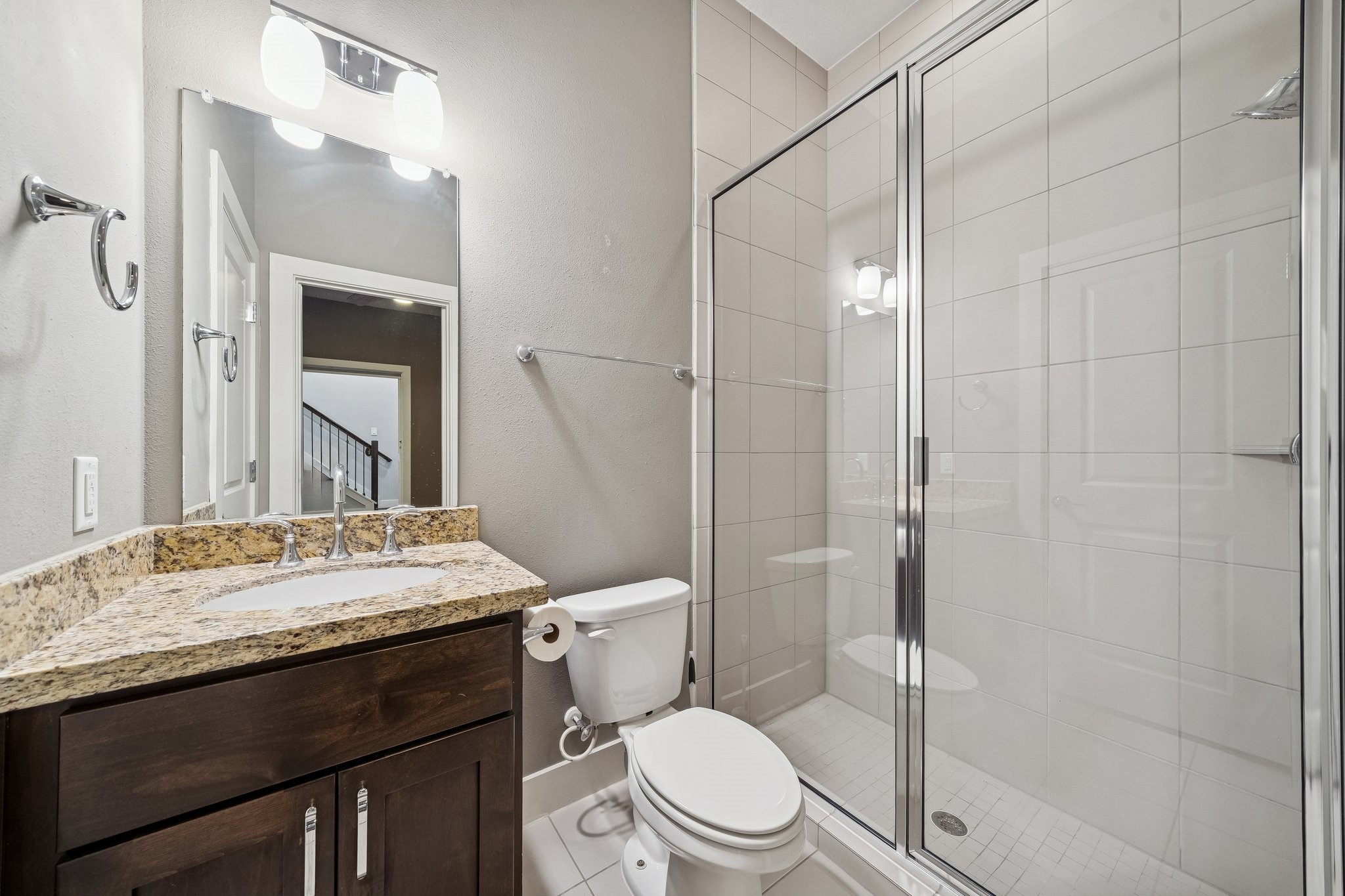 2105 Mason Street Houston, TX 77006 - Photo 22 of 43 En-suite bathroom with granite countertop, framed mirror lighting, and a glass-enclosed shower with tile surround.