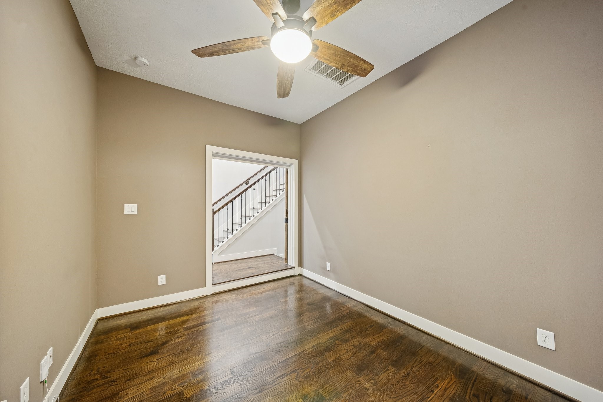 2105 Mason Street Houston, TX 77006 - Photo 25 of 43 Another view highlights the room’s clean lines, neutral walls, and generous floor space for a full bedroom set or a dedicated home office. The hardwood flooring continues throughout, and the layout offers a simple, comfortable flow.