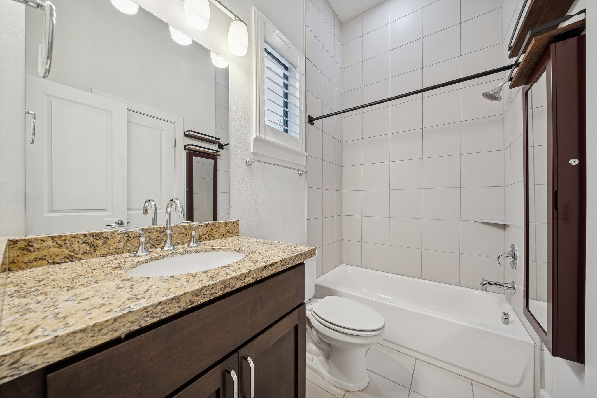 2105 Mason Street Houston, TX 77006 - Photo 26 of 43 Secondary full bath with granite vanity and a tub/shower combo finished with large-format tile surround.