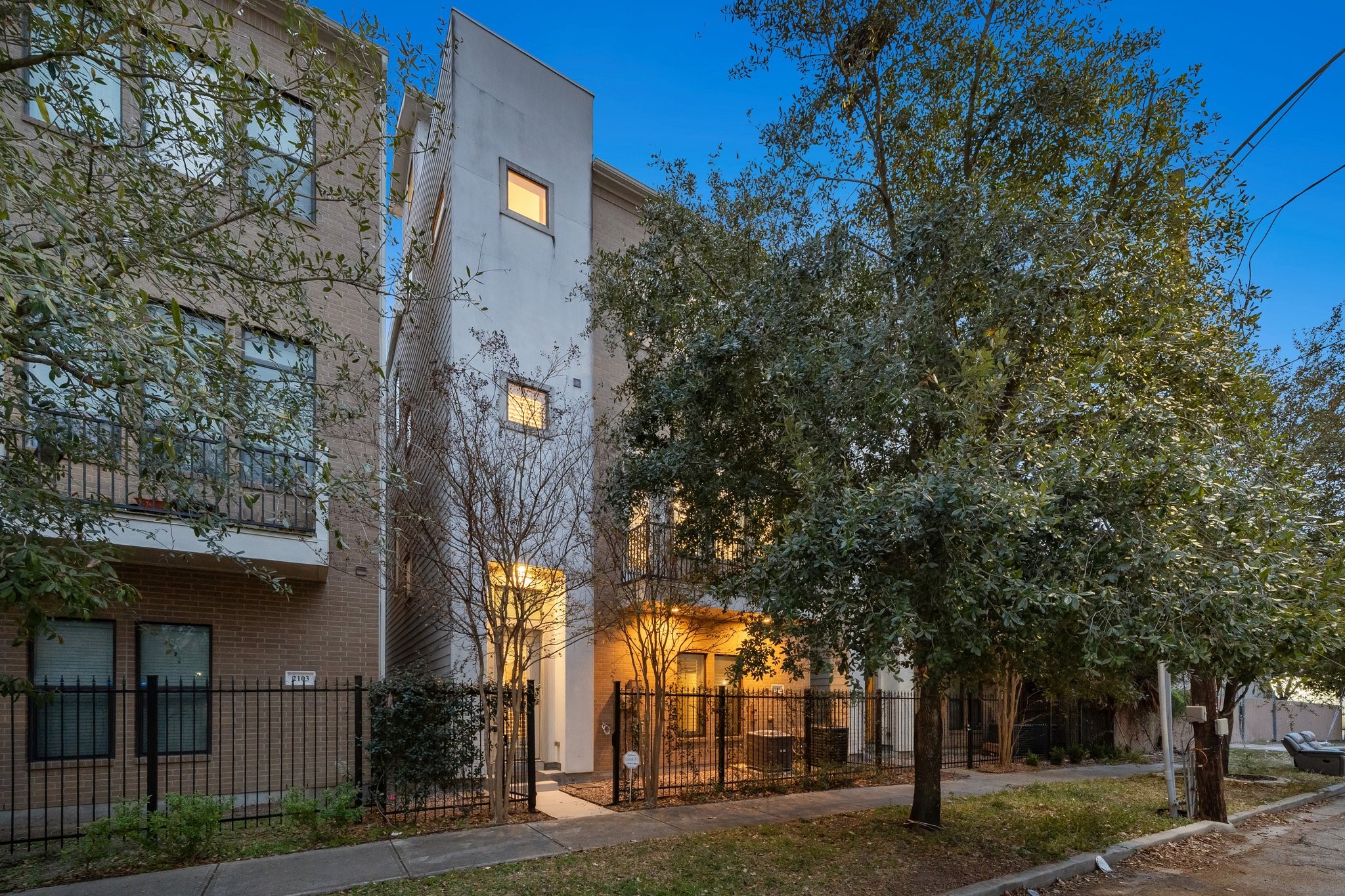 2105 Mason Street Houston, TX 77006 - Photo 39 of 43 This modern brick-and-stucco exterior pairs clean architectural lines with iron fencing and soft exterior lighting for a polished, low-maintenance look. The sidewalk-lined setting and mature trees give it a true Montrose feel—walkable, established, and close to everything.