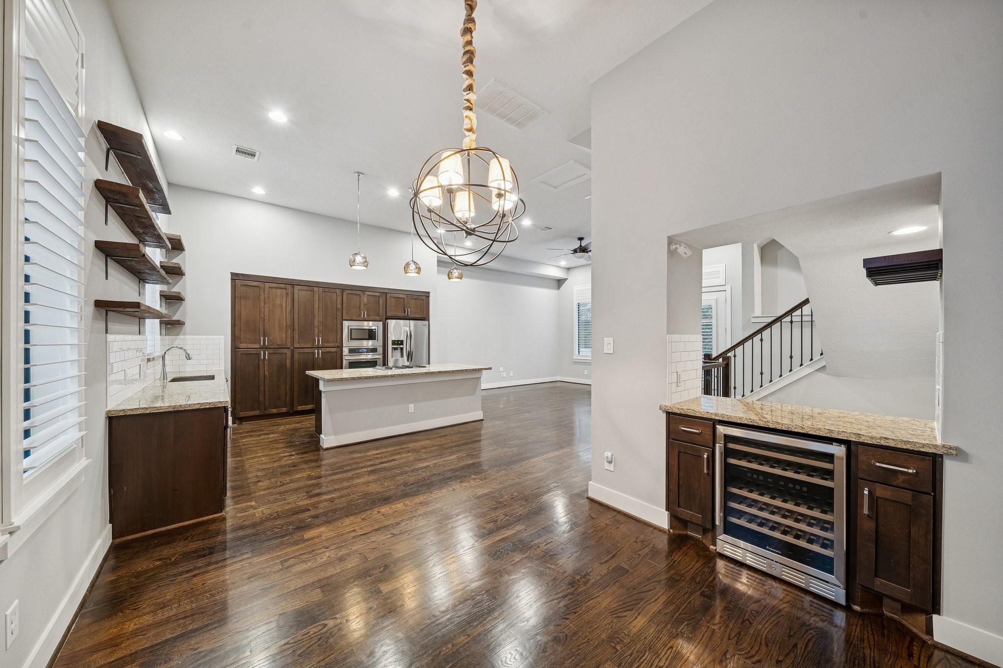 2105 Mason Street Houston, TX 77006 - Photo 7 of 43 This view from the dining area shows how the kitchen and dining connect in one continuous, open space. A built-in counter with an undercounter beverage cooler adds a convenient spot for drinks and serving. The statement dining light fixture gives the area its own identity while still flowing naturally into the kitchen.