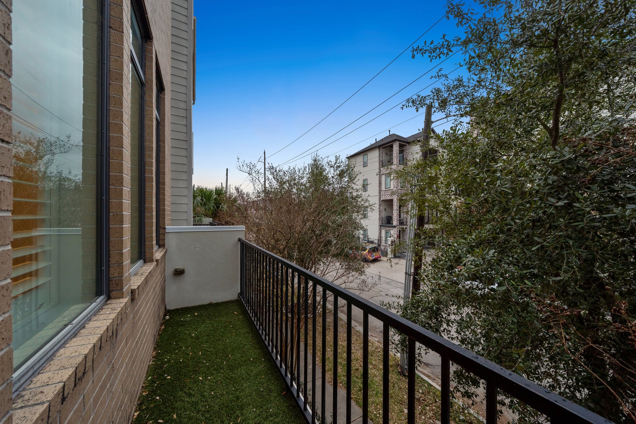 2105 Mason Street Houston, TX 77006 - Photo 9 of 43 Step out to a private balcony with room for fresh air and a quick reset between errands or evenings at home. The railing looks out over nearby trees and the surrounding neighborhood. It’s an easy outdoor bonus space that pairs nicely with the home’s layout.
