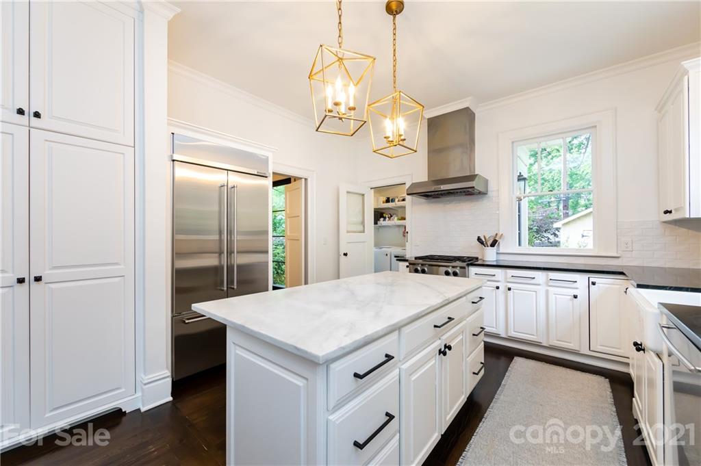 2230 Sharon Road Charlotte, NC 28207 - Photo 23 of 43 a kitchen with a white center island and stainless steel appliances