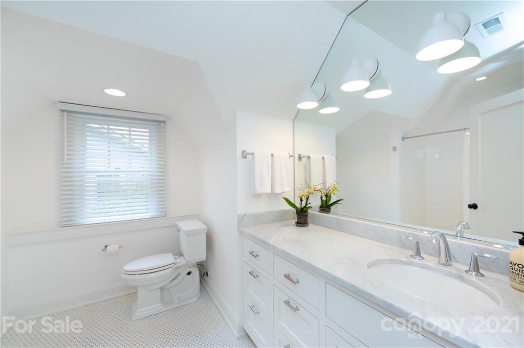 2230 Sharon Road Charlotte, NC 28207 - Photo 32 of 43 a bathroom with a granite countertop sink a toilet and a mirror