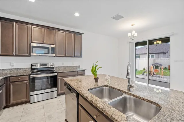 a kitchen with granite countertop a sink and a stove top oven