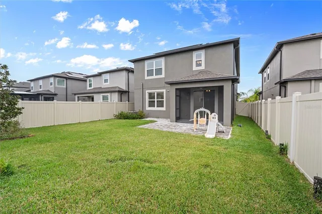 a view of a house with backyard and sitting area