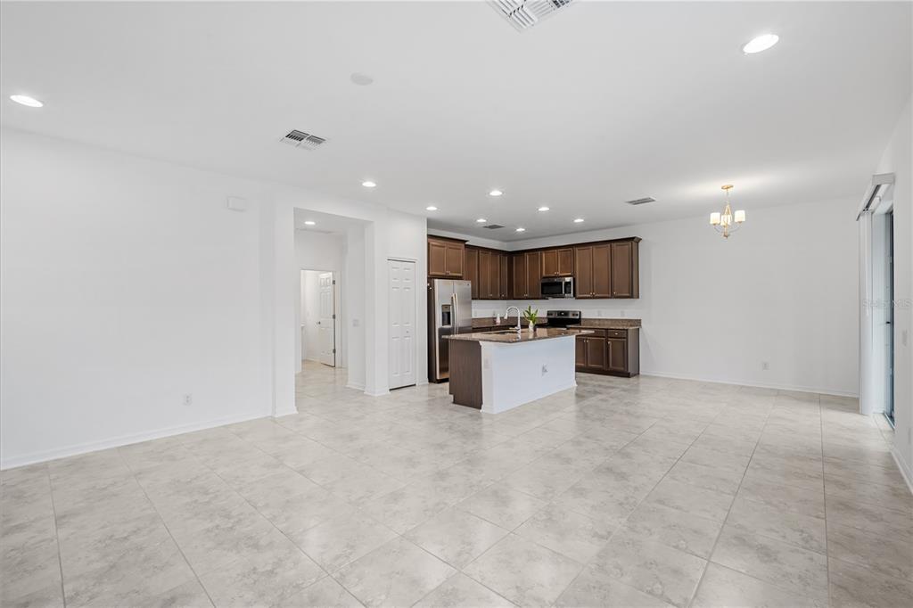 37820 Beacon Brick Drive Zephyrhills, FL 33540 - Photo 8 of 26 a kitchen with stainless steel appliances kitchen island granite countertop a stove top oven a sink and white cabinets