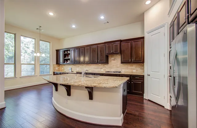 a kitchen with granite countertop a sink and wooden floor