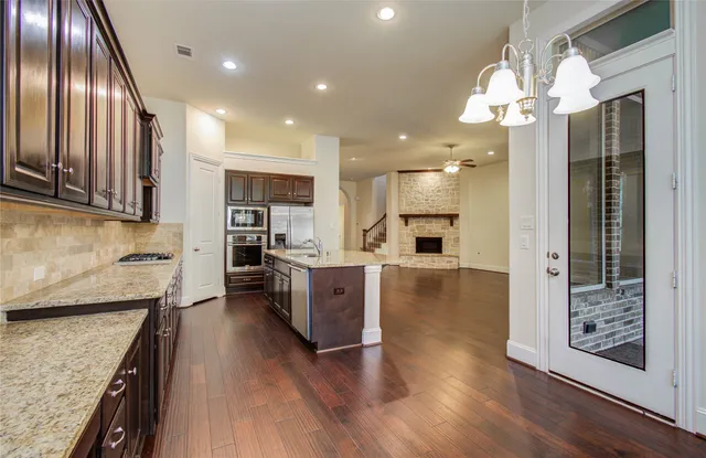 a large kitchen with cabinets wooden floor and stainless steel appliances