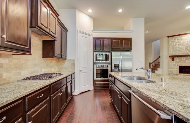 a kitchen with granite countertop stainless steel appliances and wooden cabinets