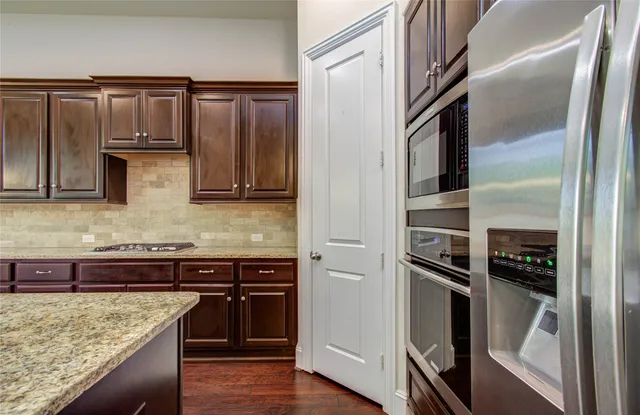 a view of an empty room with wooden floor and cabinet