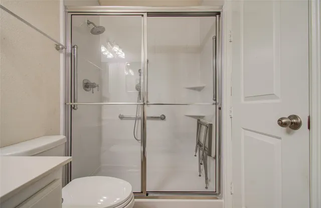 a view of an empty room and chandelier fan