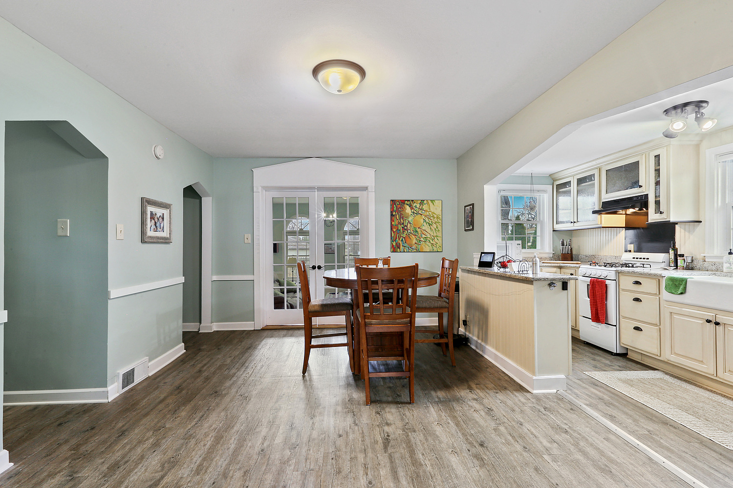6448 175th Street Tinley Park, IL 60477 - Photo 4 of 18 a kitchen with stainless steel appliances granite countertop a stove top oven a sink dishwasher a dining table and chairs with wooden floor