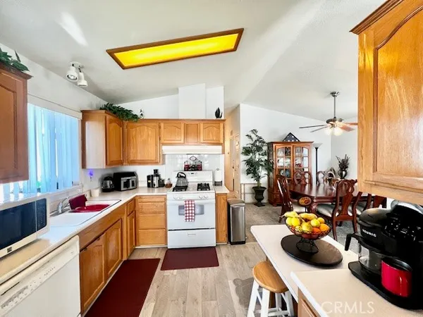a kitchen with a sink appliances cabinets and a large window