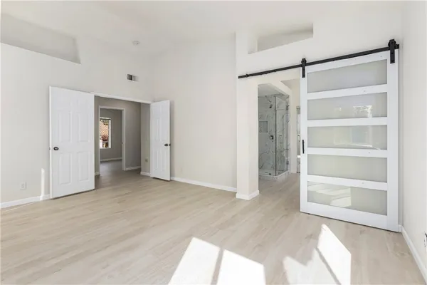 a view of an empty room with closet and a window