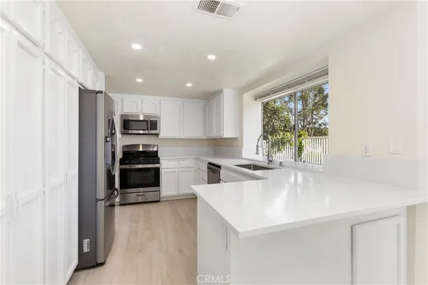 a kitchen with stainless steel appliances a sink stove and refrigerator