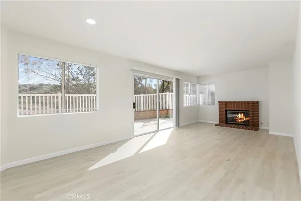 a view of an empty room with a window and a fireplace