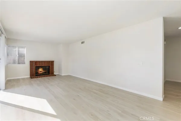 an empty room with wooden floor and fireplace
