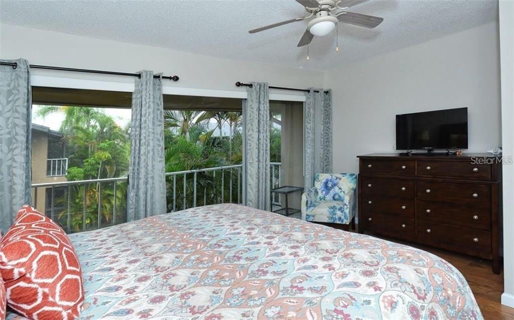 2946 Clark Road, Unit 2946 Sarasota, FL 34231 - Photo 15 of 34 a bedroom with a bed and a flat screen tv