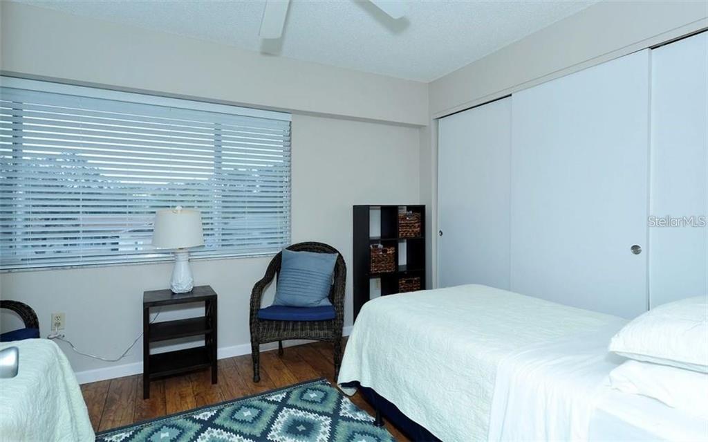 2946 Clark Road, Unit 2946 Sarasota, FL 34231 - Photo 19 of 34 a bedroom with a bed and a chair