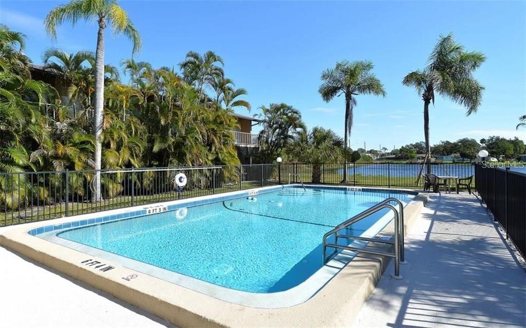 2946 Clark Road, Unit 2946 Sarasota, FL 34231 - Photo 23 of 34 a view of a swimming pool with a patio and a garden