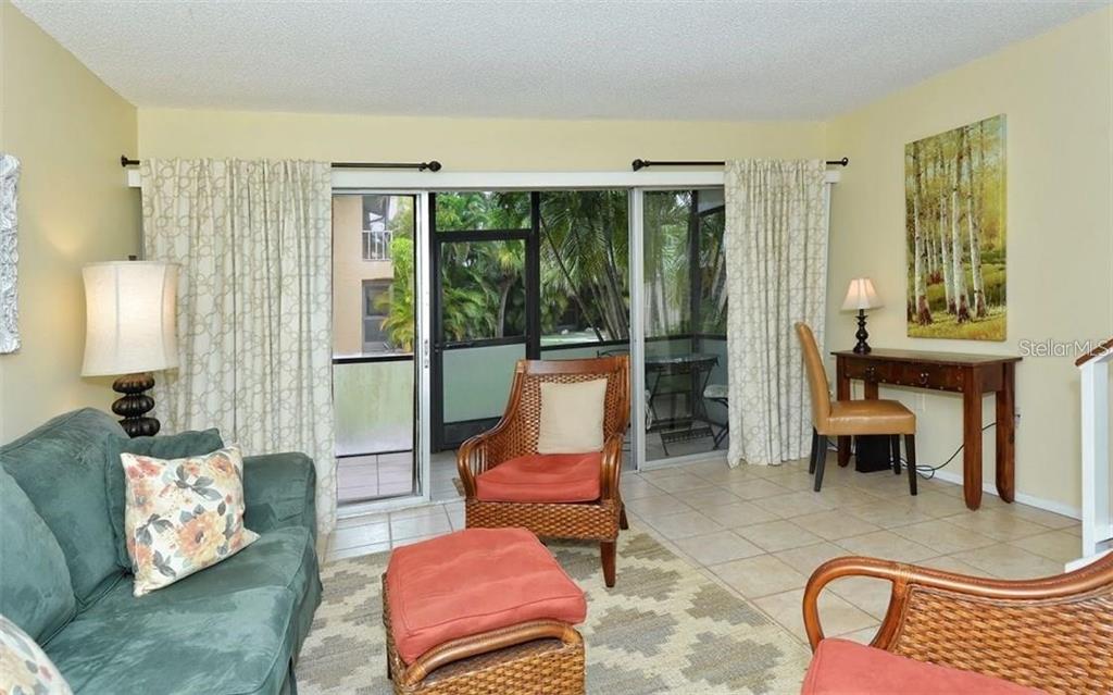 2946 Clark Road, Unit 2946 Sarasota, FL 34231 - Photo 9 of 34 a living room with furniture and a floor to ceiling window