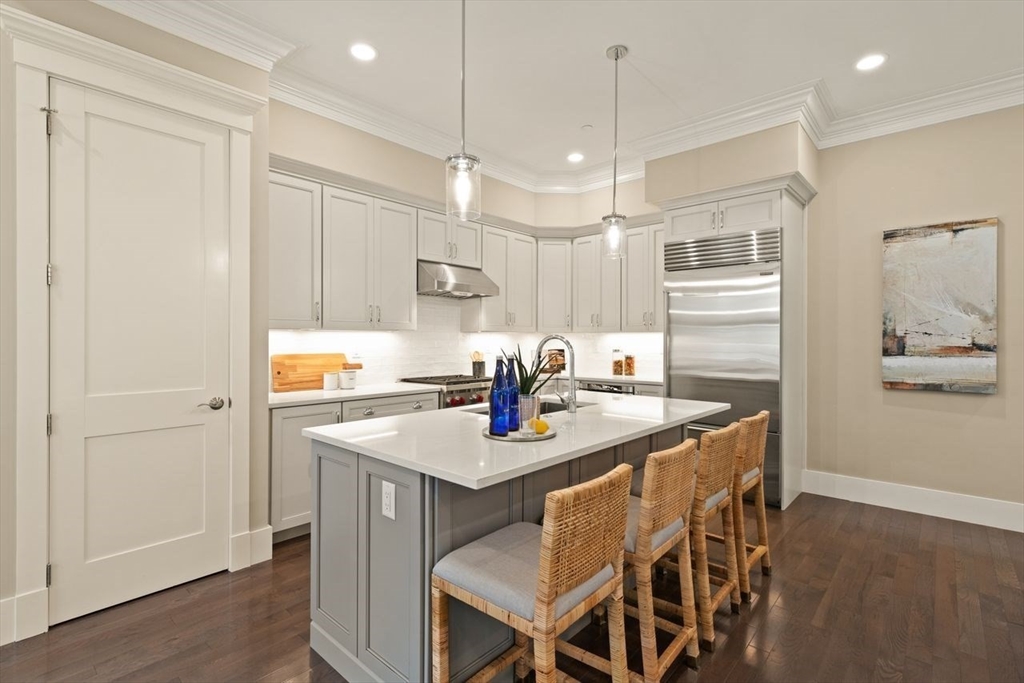 5 Gershon Way, Unit 5 Winchester, MA 01890 - Photo 7 of 27 a kitchen with a dining table chairs refrigerator and cabinets
