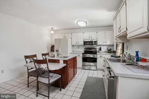 a kitchen with granite countertop a sink cabinets and stainless steel appliances