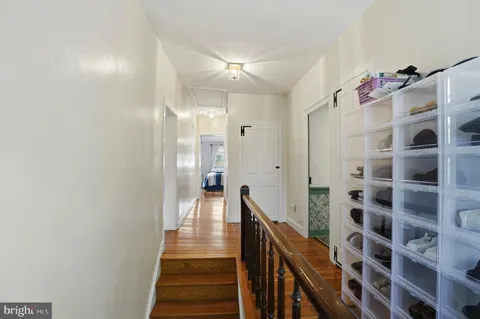 a view of a hallway with front door and wooden floor