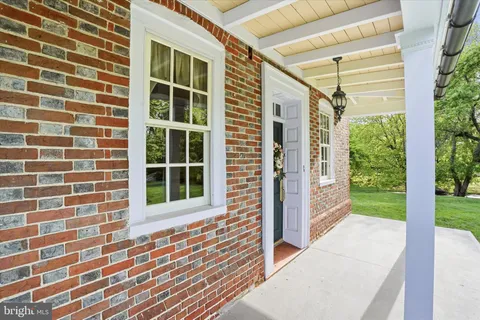 a view of front door and porch with wooden floor