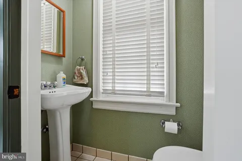 a bathroom with a sink a toilet and mirror