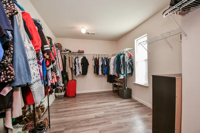a view of walk in closet with clothes and shoes