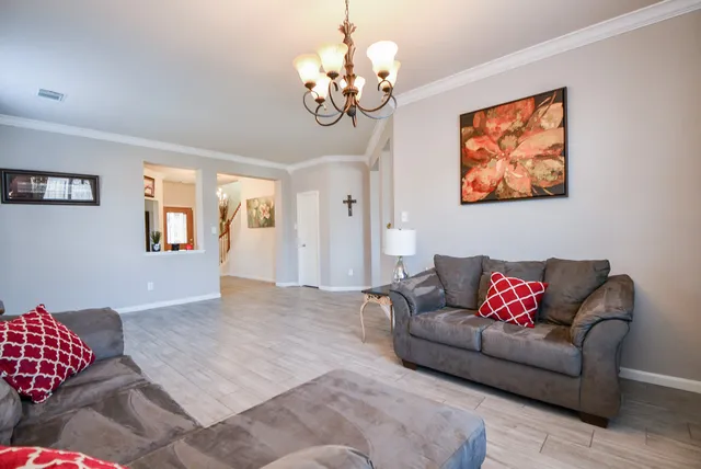 a living room with furniture and a chandelier
