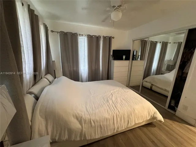a bedroom with bed and wooden floor