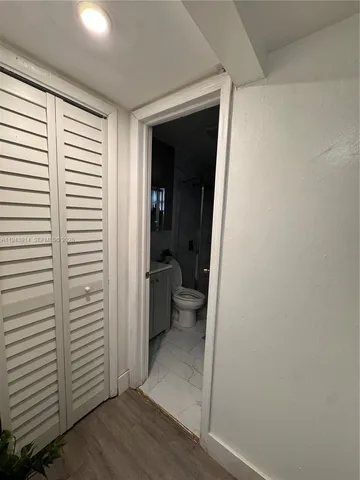 a view of a hallway with a white walls and a window