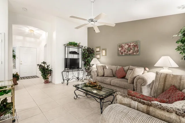 a living room with furniture a chandelier and a window