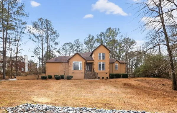 a front view of a house with a yard covered in snow