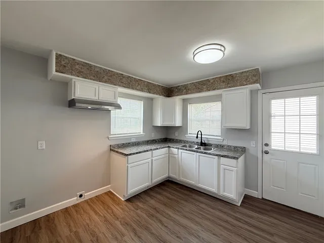 a kitchen with a sink cabinets and wooden floor