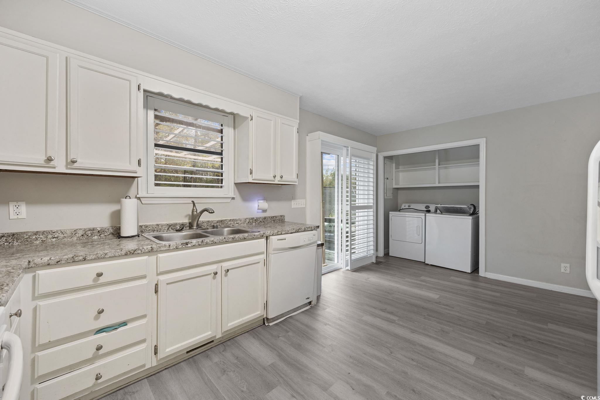 5180 Graham Street Loris, SC 29569 - Photo 13 of 28 Kitchen featuring white cabinetry, white dishwasher, light countertops, and plenty of natural light