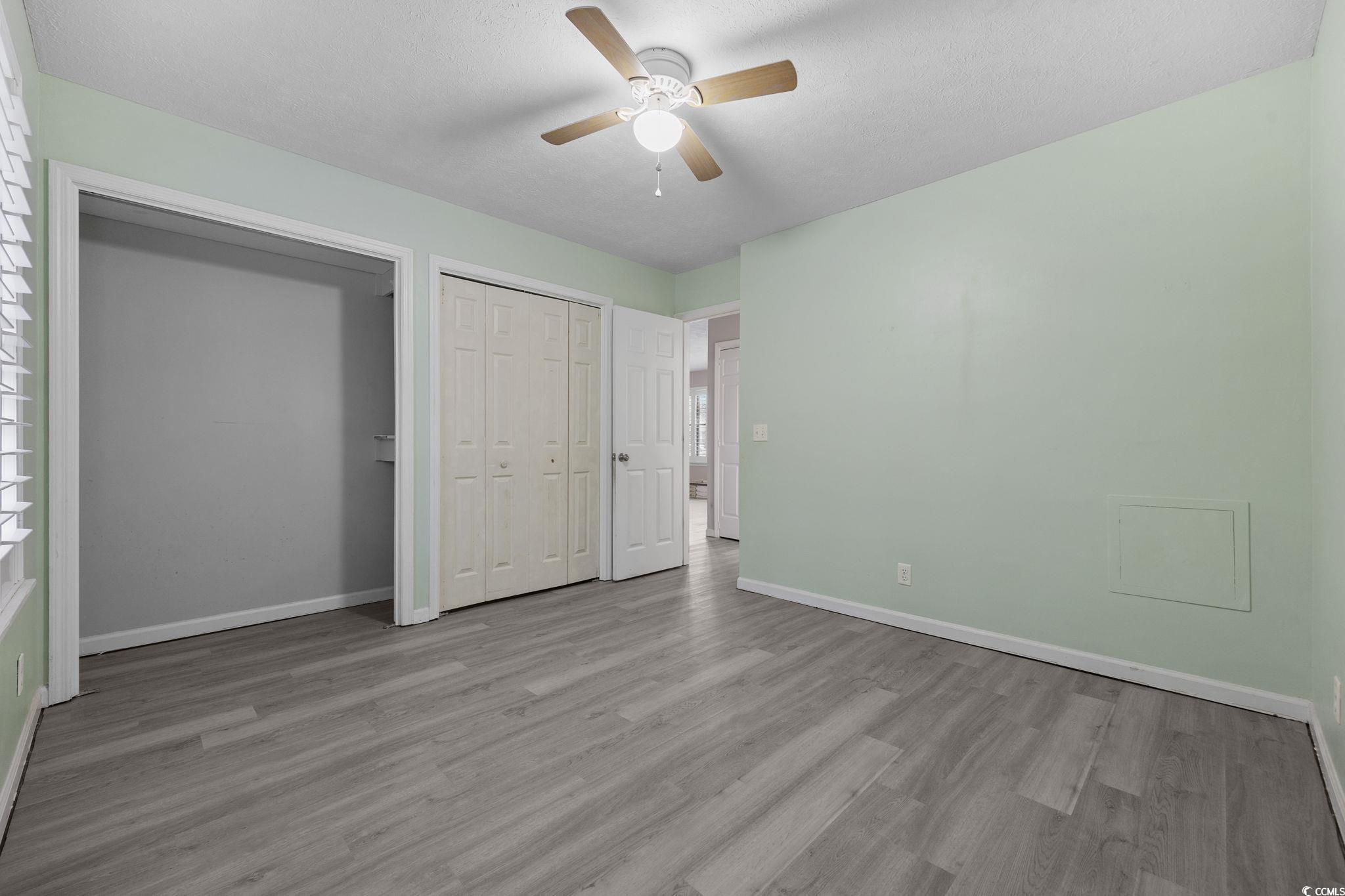 5180 Graham Street Loris, SC 29569 - Photo 21 of 28 Unfurnished bedroom featuring wood finished floors, a ceiling fan, a closet, and a textured ceiling