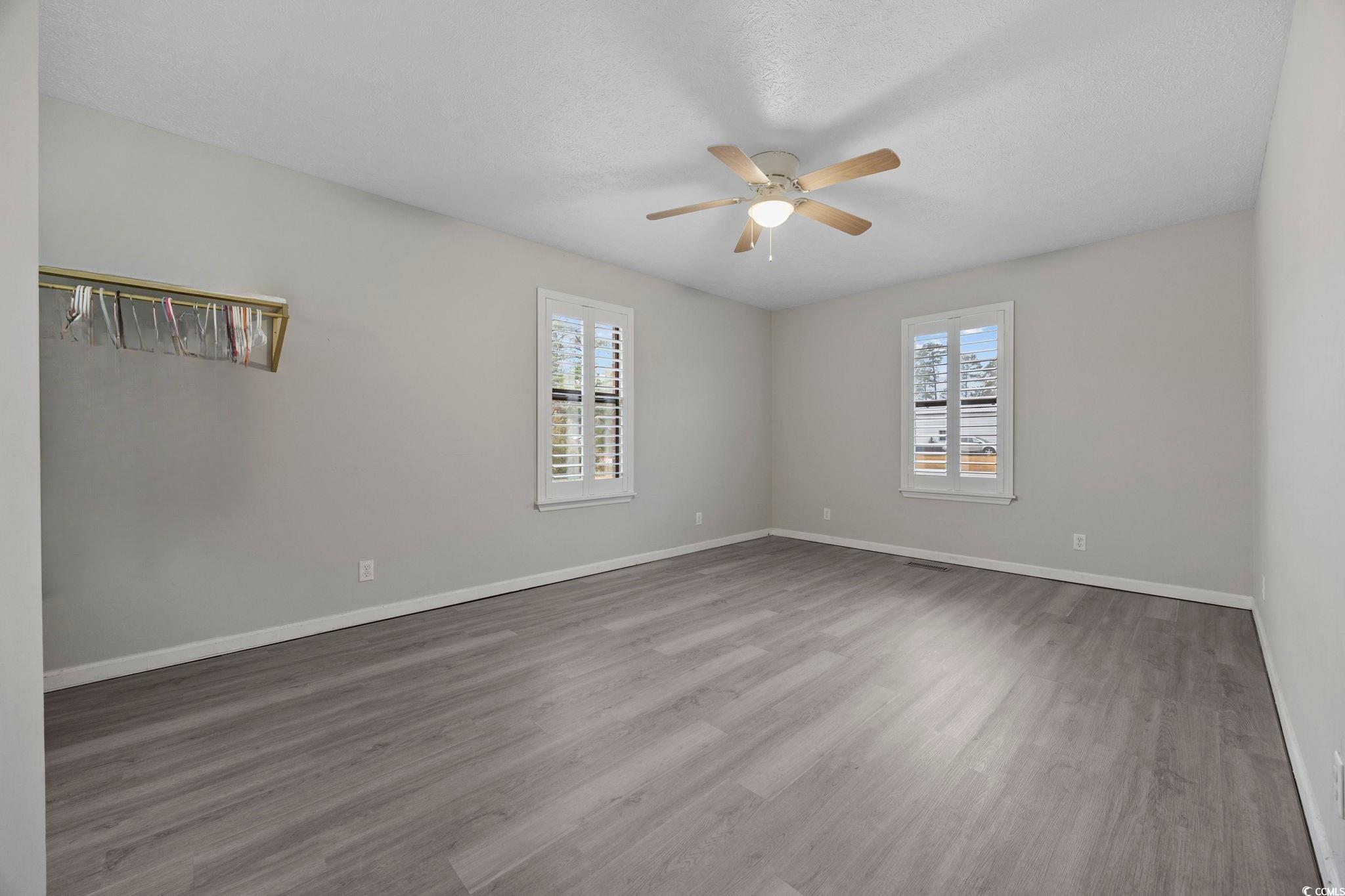 5180 Graham Street Loris, SC 29569 - Photo 7 of 28 Unfurnished room with light wood-style floors, a ceiling fan, and a textured ceiling