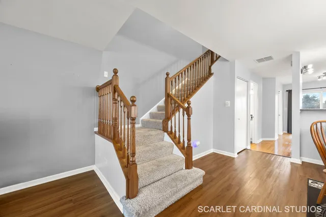 a view of a hallway with wooden floor and staircase
