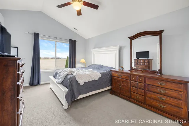 a bedroom with a large bed and a large mirror on the dresser