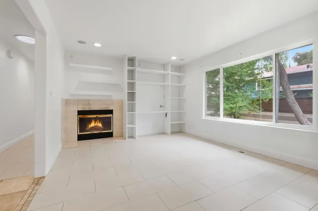 a view of an empty room with a window and a fireplace