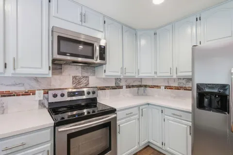 a kitchen with cabinets stainless steel appliances and a counter space