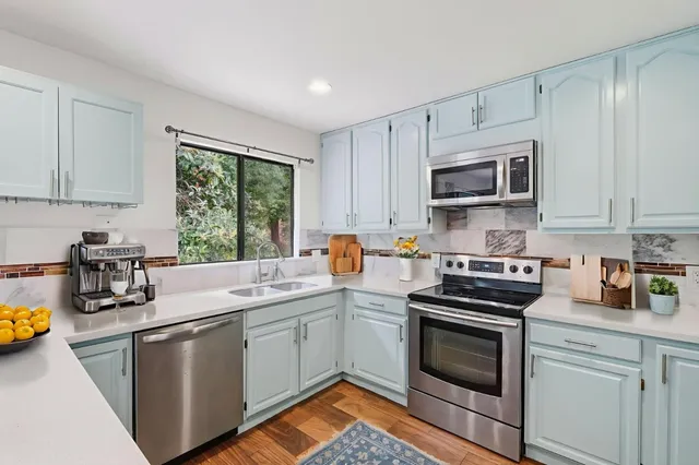a kitchen with stainless steel appliances granite countertop a stove a sink dishwasher and a microwave