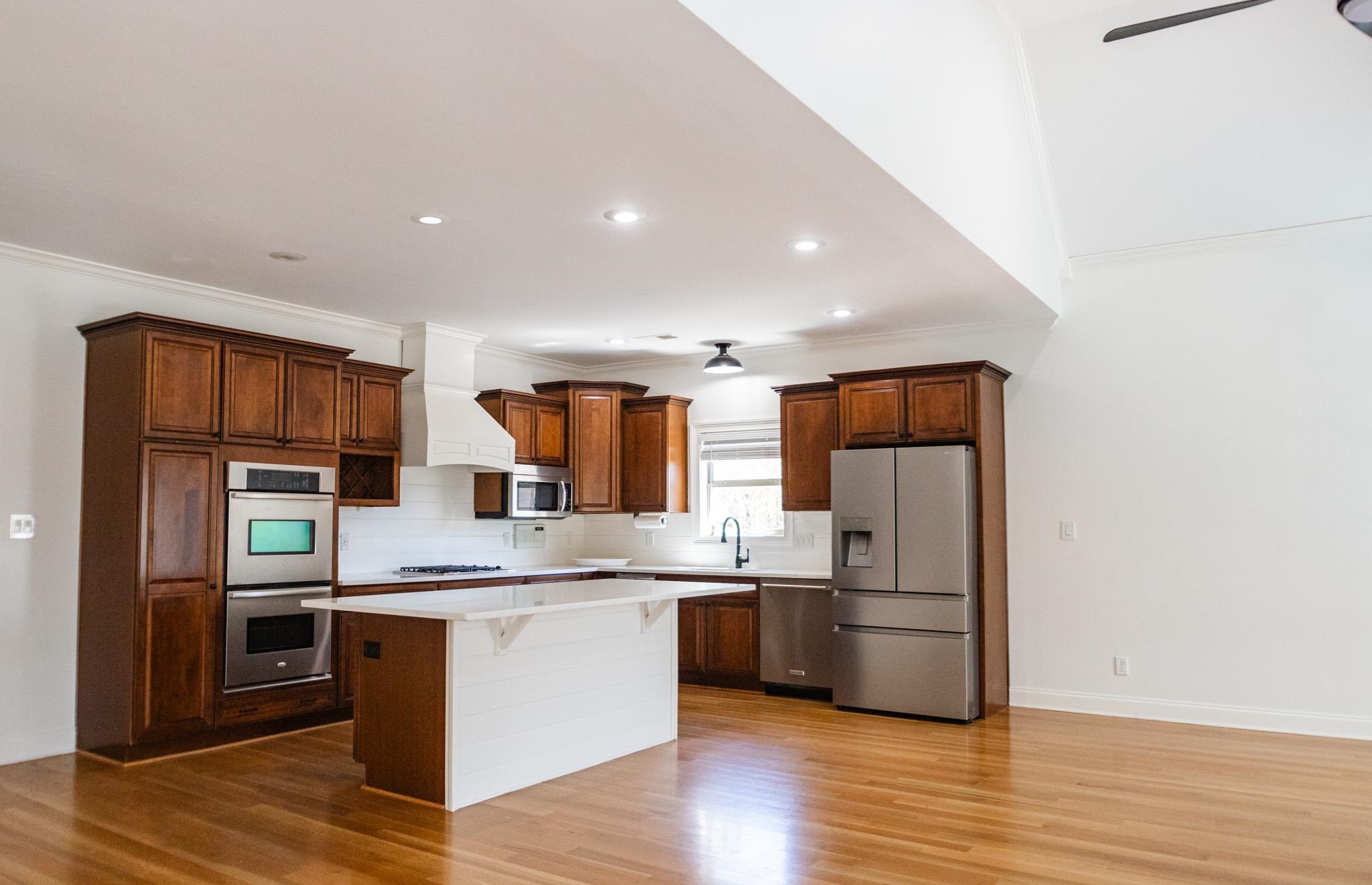 5309 Evergreen Road Lakeland, TN 38002 - Photo 11 of 40 Kitchen featuring custom range hood, light wood-style flooring, a kitchen island, and stainless steel appliances