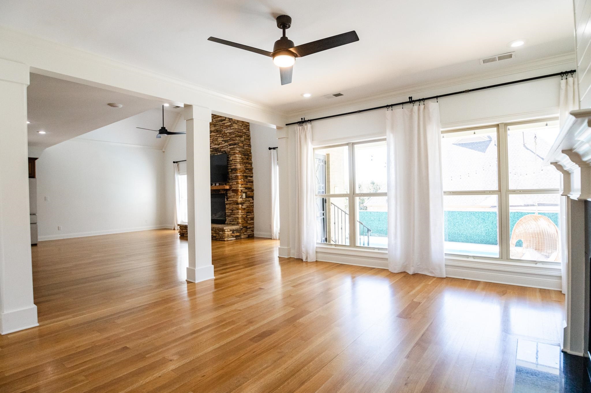 5309 Evergreen Road Lakeland, TN 38002 - Photo 14 of 40 Unfurnished living room featuring a ceiling fan, decorative columns, light wood-style floors, and a fireplace